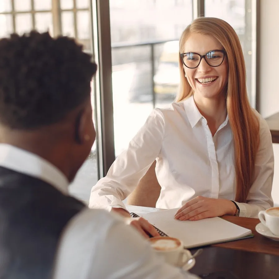 Two colleagues talking over coffee in a bright office